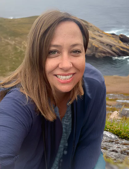 Lori Goodland outside in front of a  Newfoundland coastline